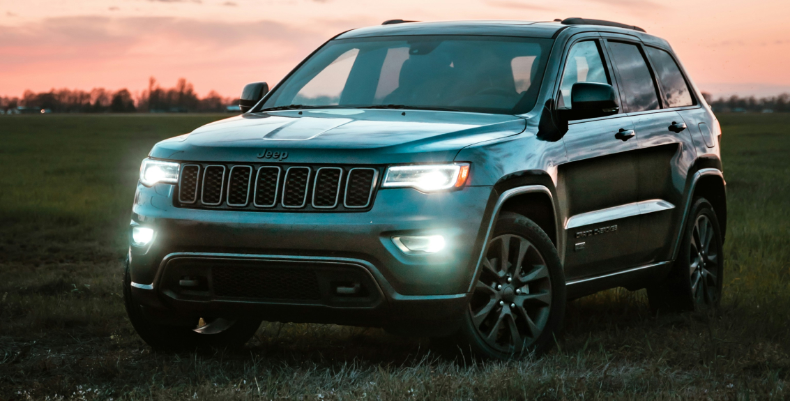 grey jeep in field at dusk